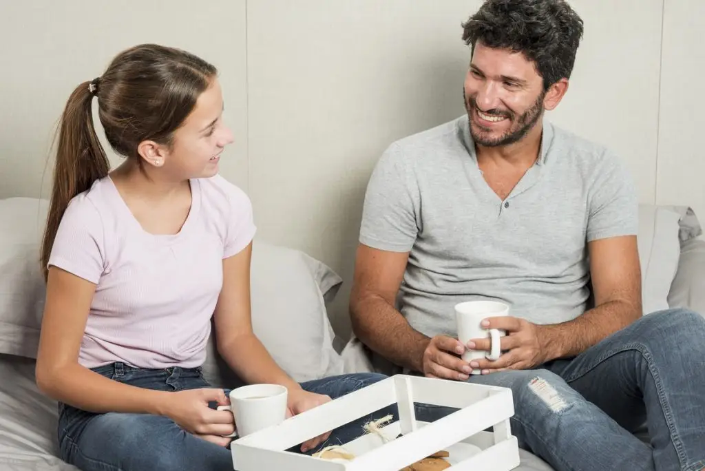 Padre escucha y mira a su hija